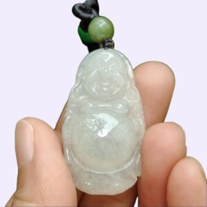 a hand holding a jade pendant