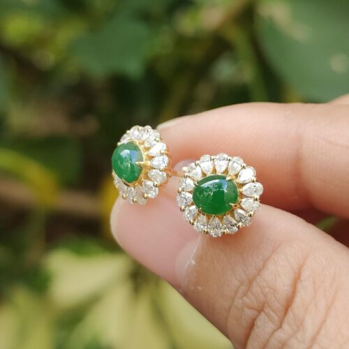 ஒரு ஜோடி காதணிகளை வைத்திருக்கும் ஒரு கை