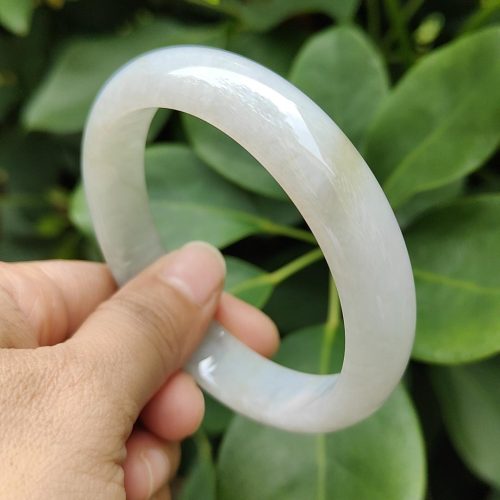 a hand holding a white bracelet