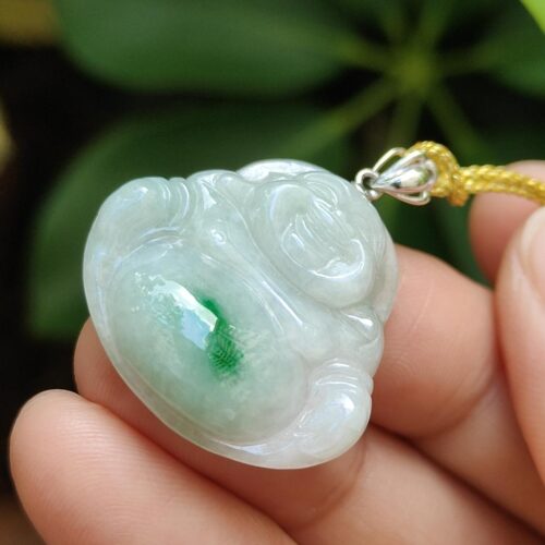 tangan memegang liontin giok