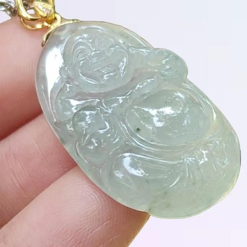 a hand holding a jade pendant