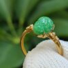 a gold ring with a green stone on it