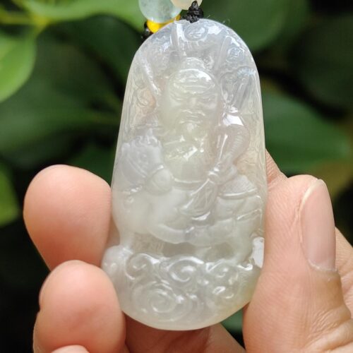 Una mano sosteniendo un colgante de jade.