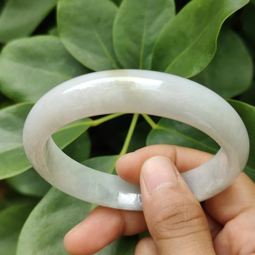 a hand holding a white bracelet