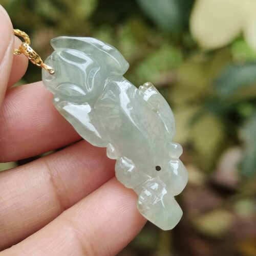 Una mano sosteniendo un colgante de jade.