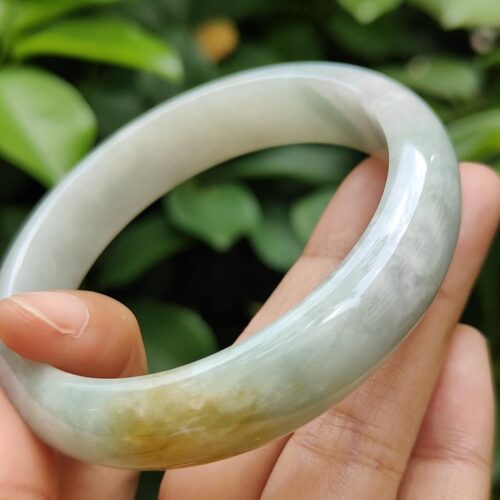 a hand holding a jade bracelet