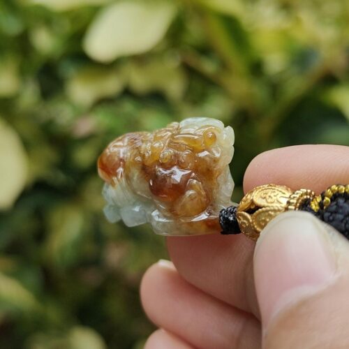 uma mão segurando um pequeno animal de pedra