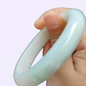 a hand holding a white circular object