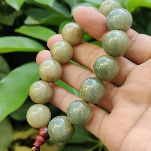 uma mão segurando uma pulseira de contas