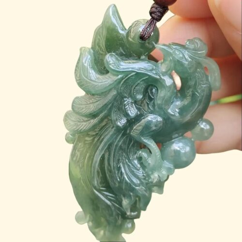 a hand holding a jade pendant