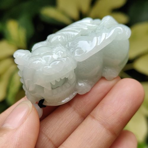 a hand holding a small white animal statue