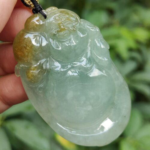 tangan memegang liontin giok