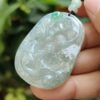 a hand holding a jade pendant