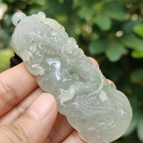 une main tenant un pendentif en jade