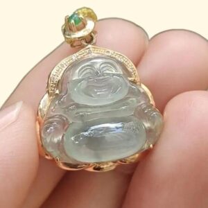 a hand holding a jade pendant