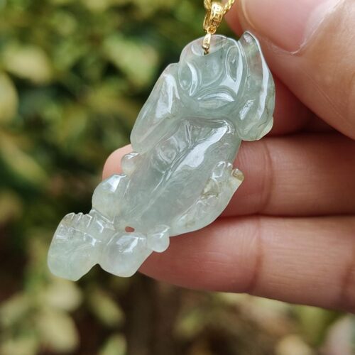 Una mano sosteniendo un colgante de jade.