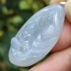 a hand holding a jade pendant