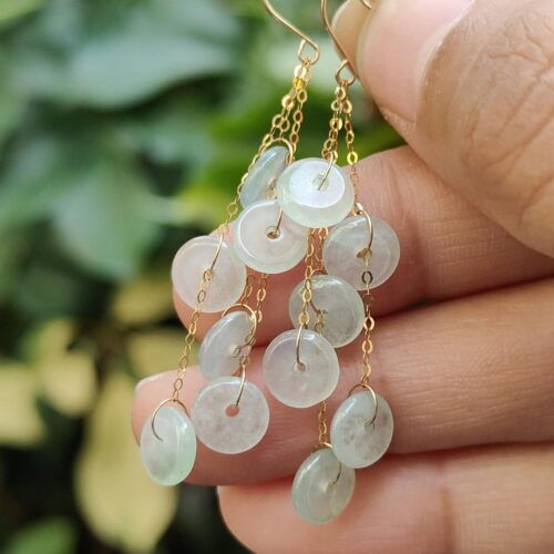 a hand holding a pair of earrings