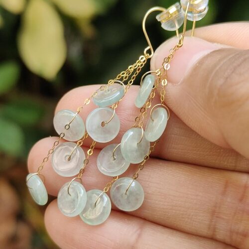 a hand holding a pair of earrings