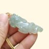 Una mano sosteniendo un colgante de jade.