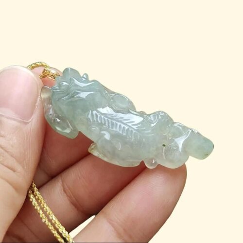 Una mano sosteniendo un colgante de jade.