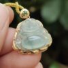 a hand holding a jade pendant