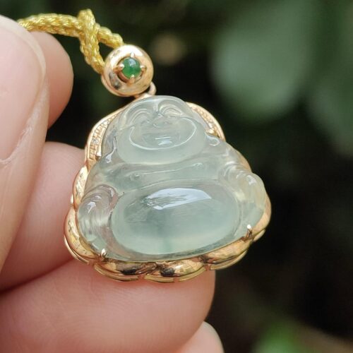 a hand holding a jade pendant