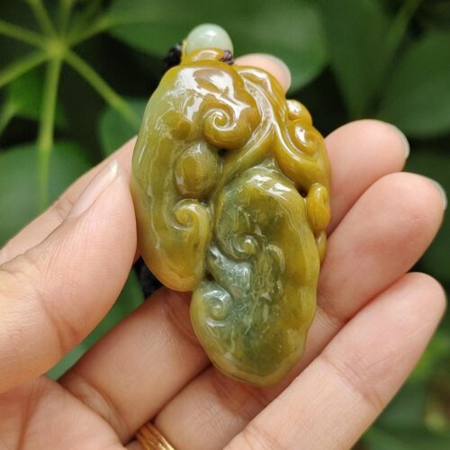 une main tenant un objet en jade