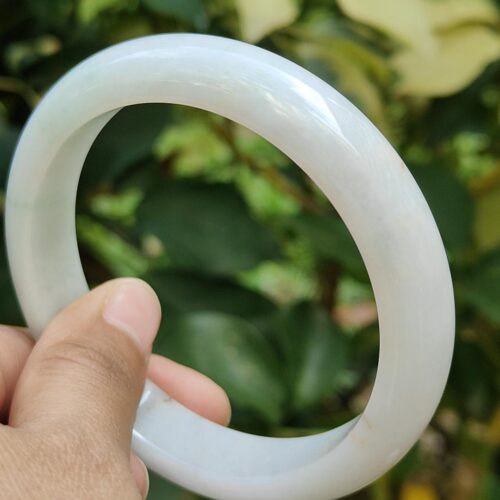 ஒரு வெள்ளை வட்டப் பொருளை வைத்திருக்கும் ஒரு கை