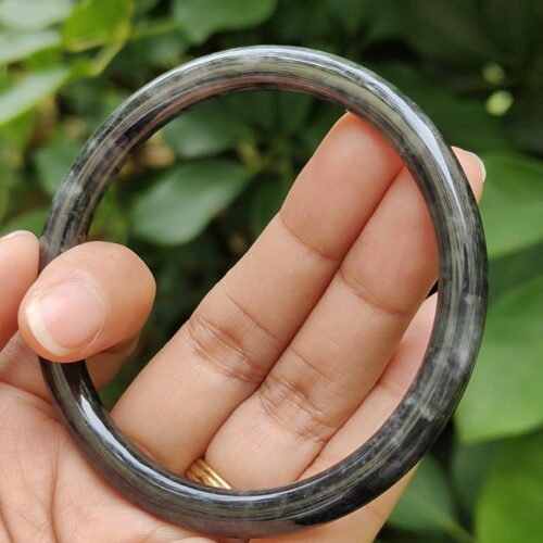 a hand holding a round black ring