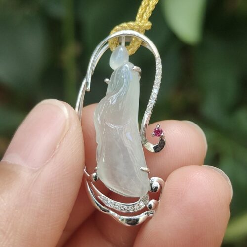 une main tenant un pendentif