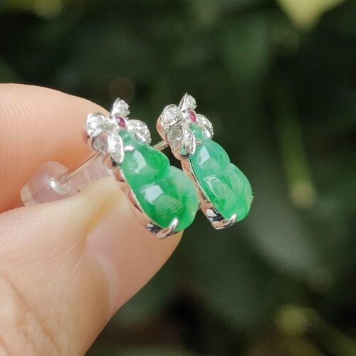 a hand holding a pair of earrings