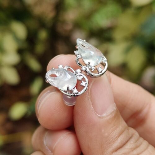 ஒரு ஜோடி காதணிகளை வைத்திருக்கும் ஒரு கை