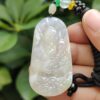 Una mano sosteniendo un colgante de jade.