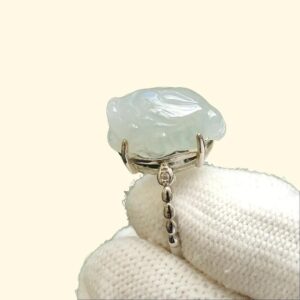 Una mano que lleva un guante blanco y que sostiene un anillo.