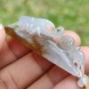a hand holding a jade pendant
