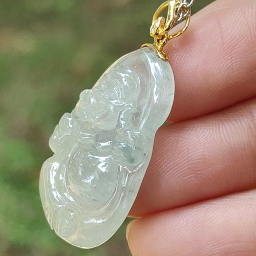 a hand holding a jade pendant