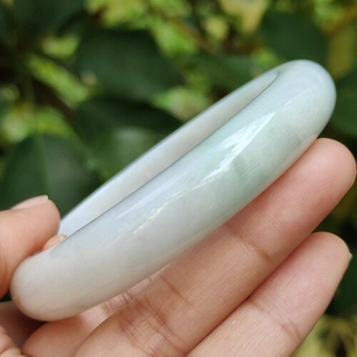 a hand holding a white bracelet