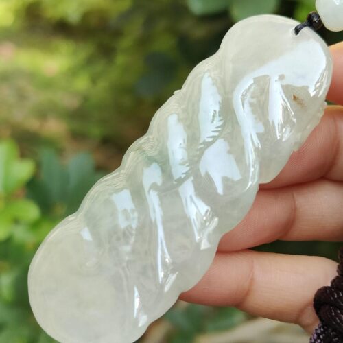 une main tenant un collier de jade