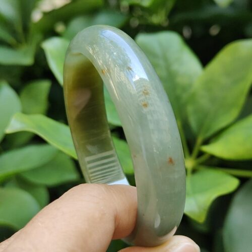 a hand holding a jade bracelet