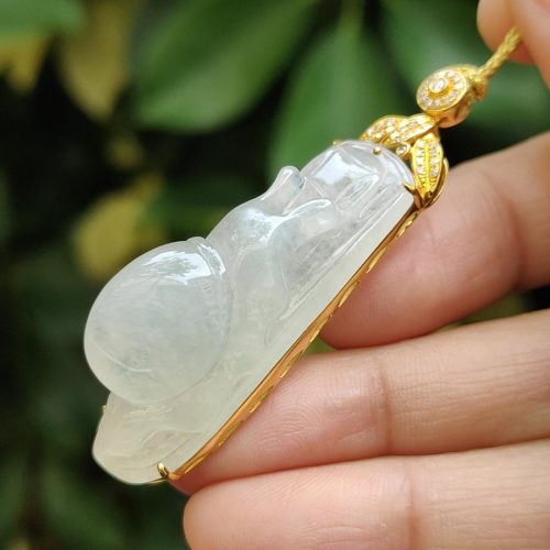 a hand holding a jade pendant