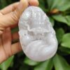 a hand holding a white jade object