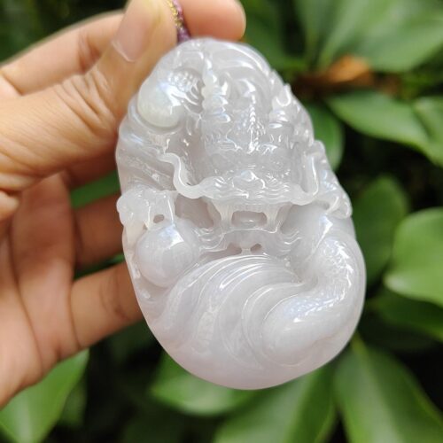 a hand holding a white jade object