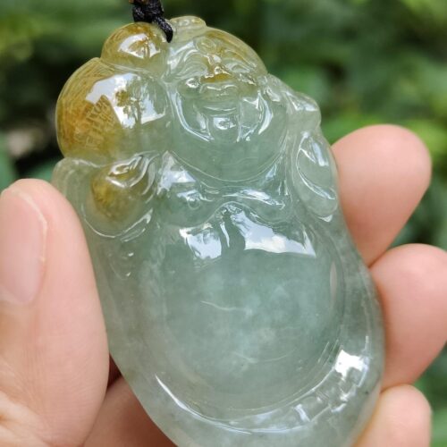 a hand holding a jade buddha