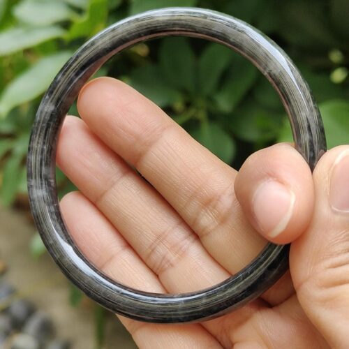a hand holding a round black ring
