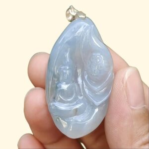 a hand holding a blue stone pendant