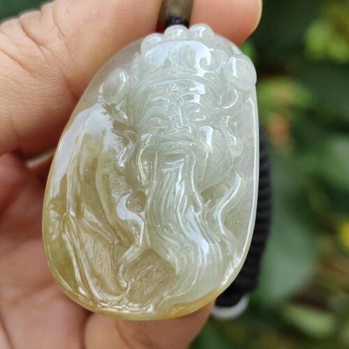 a hand holding a jade pendant