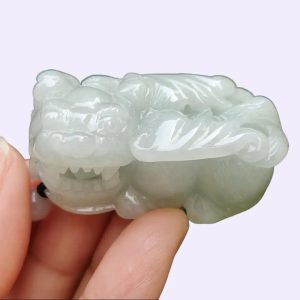 a hand holding a small white stone animal