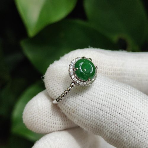 a hand wearing a gloved hand holding a ring