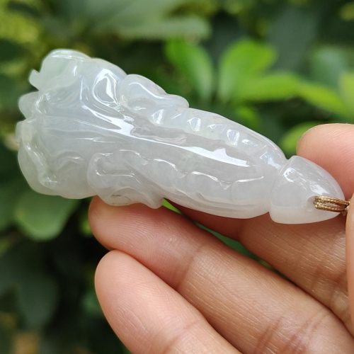 a hand holding a jade pendant